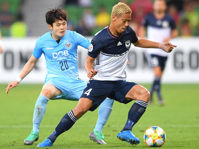 Keisuke Honda controls the ball in front of Hwang Soonmin.