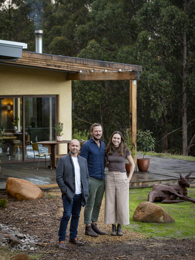 Host Anthony Burke with homeowners Dan Rawlins and Chloe Meyer on their property at Franklin, Tasmania. Picture: Brad Harris