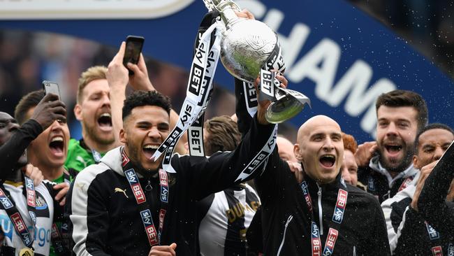 Newcastle United players Jamaal Lascelles (l) and Jonjo Shelvey lift the trophy.