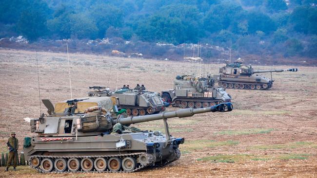 Israeli soldiers armed with artillery cannons man their position at an undisclosed location in northern Israel bordering Lebanon on October 8.