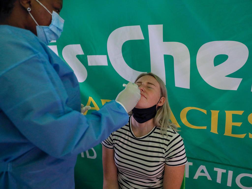 A healthcare worker conducts a PCR Covid-19 test on a traveller at OR Tambo International Airport in Johannesburg. Picture: Phill Magakoe/AFP