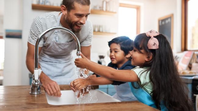 Cropped shot of a man and his two children washing their hands in the kitchen basin