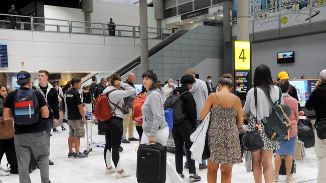 Crowds of people at the Brisbane airport after getting one of the last flights. Passenger getting off one of the last flights from interstate before the lockout. (AAP image, John Gass)