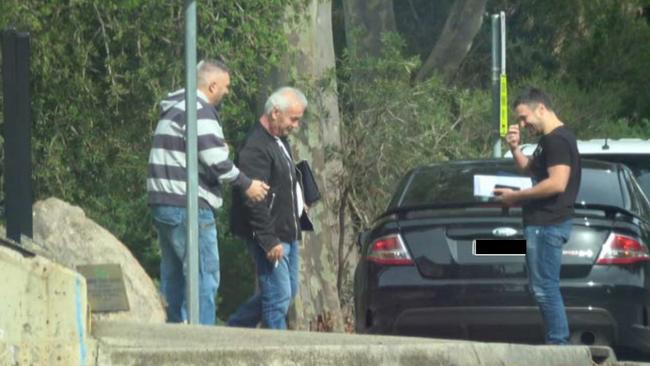 Peter Bollas, George Haritos and a Transclean associate are photographed meeting near Epping train depot on May 6.