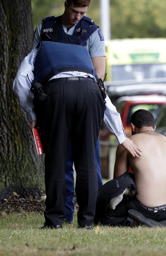 Police console a man outside a mosque in central Christchurch, New Zealand. Picture: AP