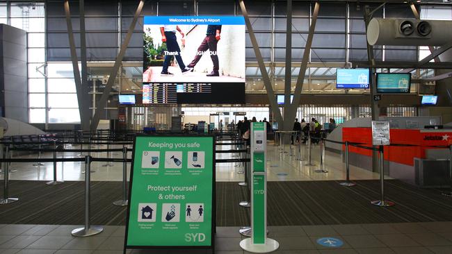 COVID-19 signage at an empty Sydney Airport. Picture: Lisa Maree Williams/Getty Images.