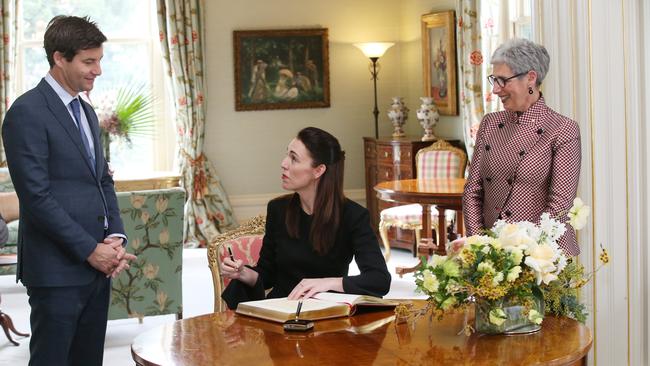 Victoria Governor Linda Dessau, right, watches as Jacinda Ardern and partner Clarke Gayford sign the visitor book. Picture: AAP