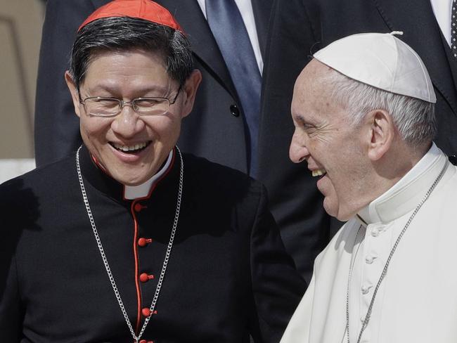 FILE - Pope Francis greets Cardinal Luis Antonio Tagle, archbishop of Manila, second from right, and group of migrants, during his weekly general audience, at the Vatican, Wednesday, Sept. 27, 2017. (AP Photo/Andrew Medichini, File)