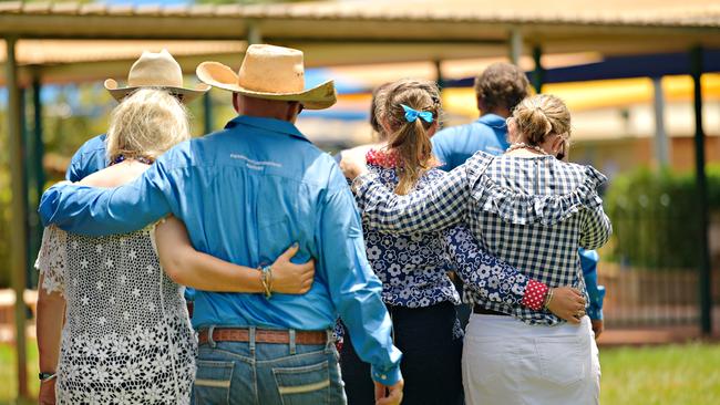 Tick Everett (blue), and Meg Everett (blue hair ribbon) supported by family at Casuarina Street primary school after Dolly Everett's memorial service in Katherine, Northern Territory.