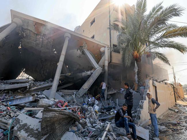 Palestinians sit on the rubble of a collapsed building following an Israeli strike, in Khan Yunis in the southern Gaza Strip, which is running out of water. Picture: AFP