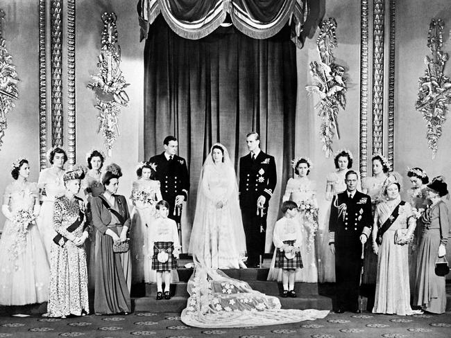 Members of the British Royal family and guests pose around Princess Elizabeth (future Queen Elizabeth II) (CL) and Philip, Duke of Edinburgh (CR) (future Prince Philip); at right the group includes Britain's King George VI (5R) stood next to Queen Elizabeth (3R) with Princess Alice of Athlone (R) and in front of bridemaids that include Princess Margaretb (7R) stood next to Philip; at left the group includes the best man David Mountbatten, Marquess of Milford Haven (7L) stood next to Princess Elizabeth, Mary of Teck (3L), mother of King George VI, stands at left in front of the bridesmaids next to Princess Alice of Battenberg (5L), Philip's mother; the page boys are Prince William of Gloucester and Prince Michael of Kent; in the Throne Room at Buckingham Palace on their wedding day.