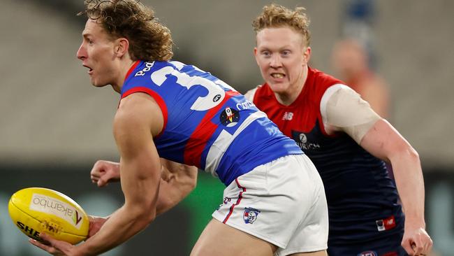 MELBOURNE, AUSTRALIA – JULY 24: Aaron Naughton of the Bulldogs is chased by Clayton Oliver of the Demons during the 2021 AFL Round 19 match between the Melbourne Demons and the Western Bulldogs at the Melbourne Cricket Ground on July 24, 2021 in Melbourne, Australia. (Photo by Michael Willson/AFL Photos via Getty Images)