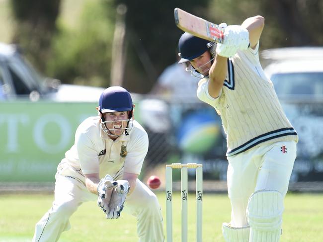 Baxter batsman Daniel Warwick plays an off drive as Mt Eliza keeper Tim Clarke looks on.