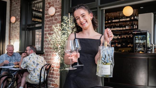 Patron Tiana Matthews collects her wine and glasses after paying, instead of waiting for table service at Perth’s Vincent Wine. Picture: Tony McDonough