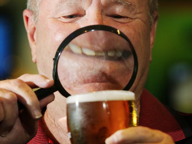Beer company Lion is introducing nutritional information on the labels of their beer brands, which include popular brands such as XXXX, Hahn and James Squire. Retiree Jeff Prime inspects his XXXX Gold at Cazalys. PICTURE: BRENDAN RADKE.