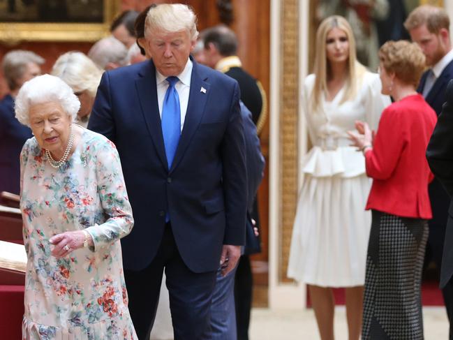 Queen Elizabeth II (L) and US President Donald Trump (2nd L) view the Royal collection while Ivanka Trump (4th R) speaks with Prince Harry (2nd R) at Buckingham Palace. Picture: Getty Images