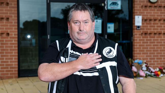 Port Adelaide fan Mathew Smith leaves flowers at Alberton Oval in honour of Russell Ebert. Picture: Brenton Edwards