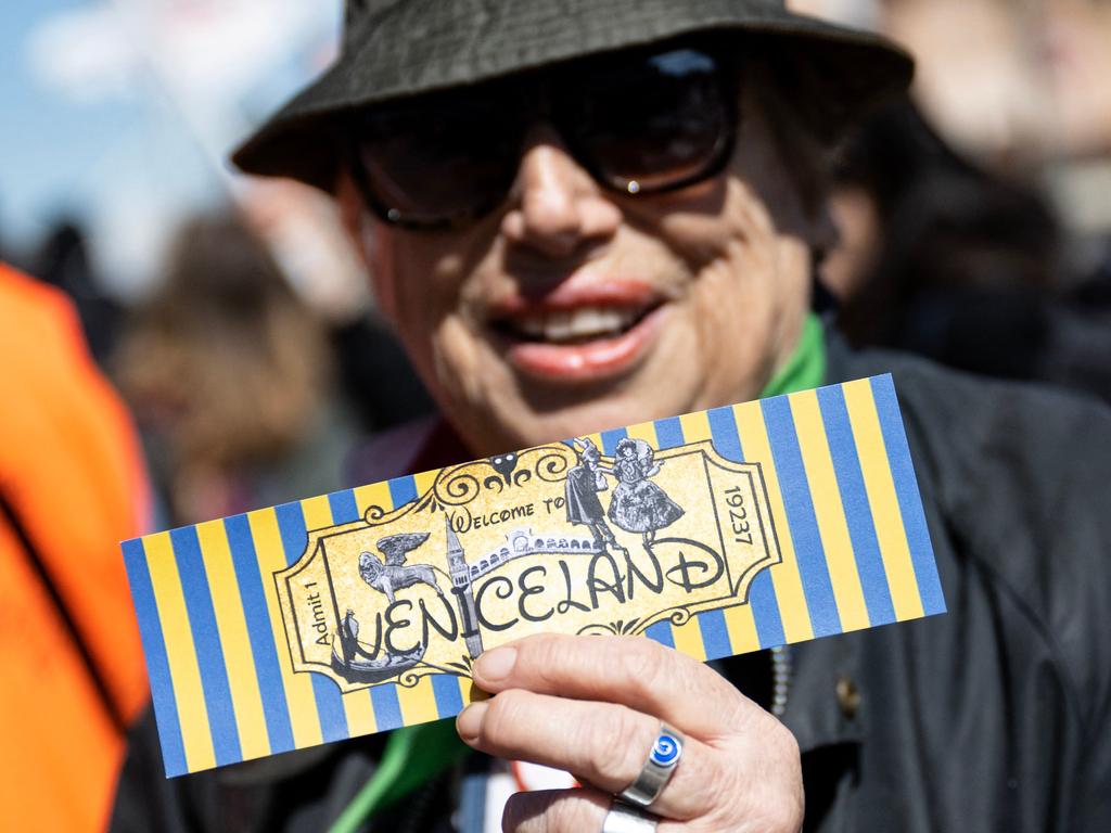 A woman holds a ticket reading ‘Welcome to Veniceland’ as she protests against the new scheme. Picture: Marco Bertorello / AFP