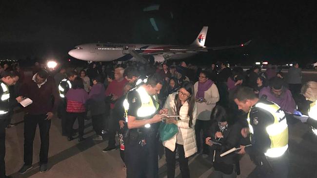 Andrew Leoncelli supplied this photograph showing passengers being interviewed by police on the tarmac after the incident.