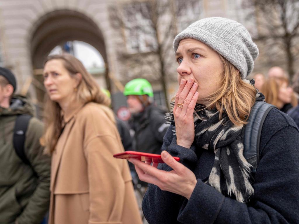 People react as the Stock Exchange building burns in central Copenhagen, Denmark. Picture: Ritzau Scanpix / AFP) / Denmark OUT