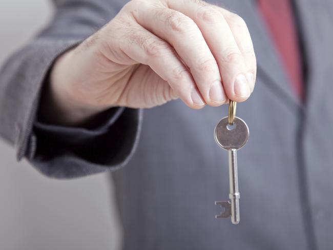 Landlord/ realtor holding out a key to your new home