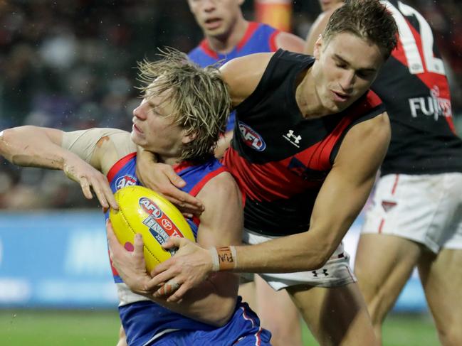 LAUNCESTON, AUSTRALIA - AUGUST 29: Cody Weightman of the Bulldogs is tackled by Matt Guelfi of the Bombers during the 2021 AFL First Elimination Final match between the Western Bulldogs and the Essendon Bombers at University of Tasmania Stadium on August 29, 2021 in Launceston, Australia. (Photo by Grant Viney/AFL Photos via Getty Images)