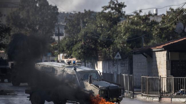 Israeli army jeeps are seen near burning tyres during an incursion at the entrance of the Jenin refugee camp in Jenin. Picture: Marco Longari