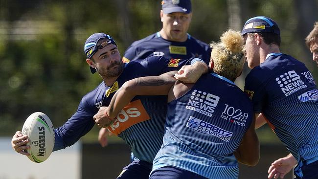 Keegan Hipgrave (left) runs the ball during a Titans training session on Monday. Picture: AAP.