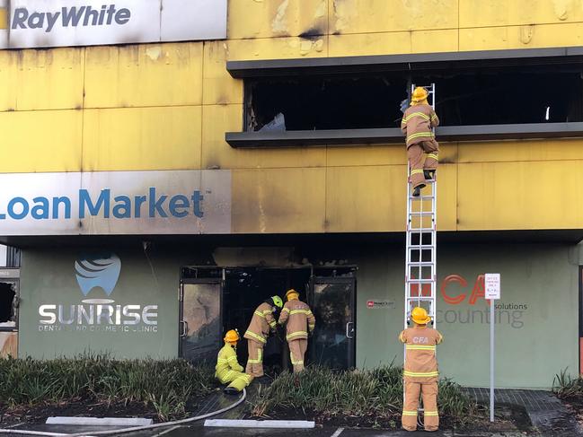 Fire crews check out the damage to the Ray White building in Plenty.