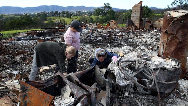 ***EMBARGOED FOR SUNDAY TELEGRAPH***Bushfire recovery on the NSW south coast has begun with the removal of what remained of homes burnt down by the New Year's Eve fires and some locals ready to begin the rebuilding process. Rebecca Sloane and kids Alex and Jack sift through the remains of their burnt down home near Galba, Cobargo before the heavy machinery moved in to clear the rubble. Picture: Toby Zerna