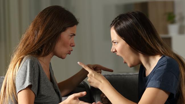 Side view portrait of two friends arguing and shouting in the night at home; ; family fight argument generic