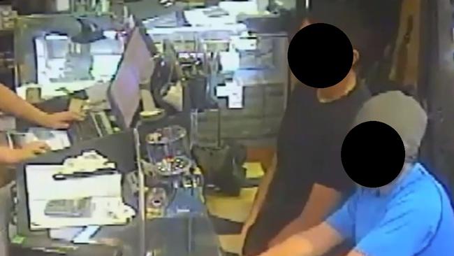 XY inside the shop buying two large hunting knives.