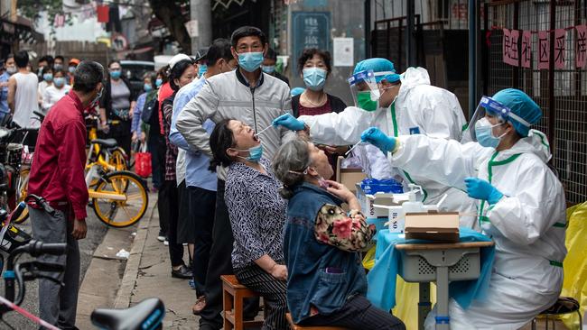 Medical workers take swab samples from residents to be tested for the COVID-19 coronavirus in a street in Wuhan in China's central Hubei province. Picture: AFP