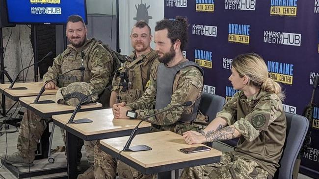 Emese Fajk, who allegedly attempted to con Channel 9's The Block, pictured fronting a press conference alongside three foreign fighters.