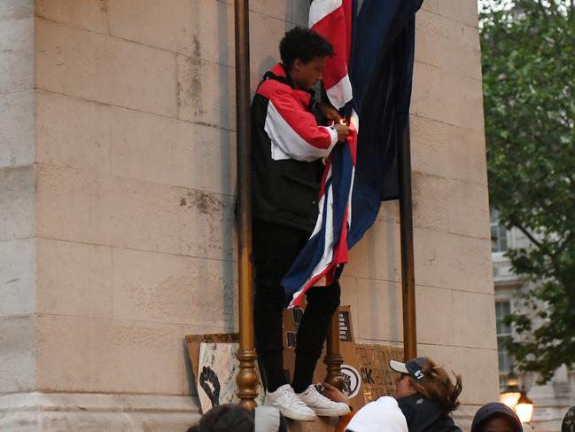 A protester attempts to set fire to the flags on the Cenotaph memorial in London. Picture: Getty Images