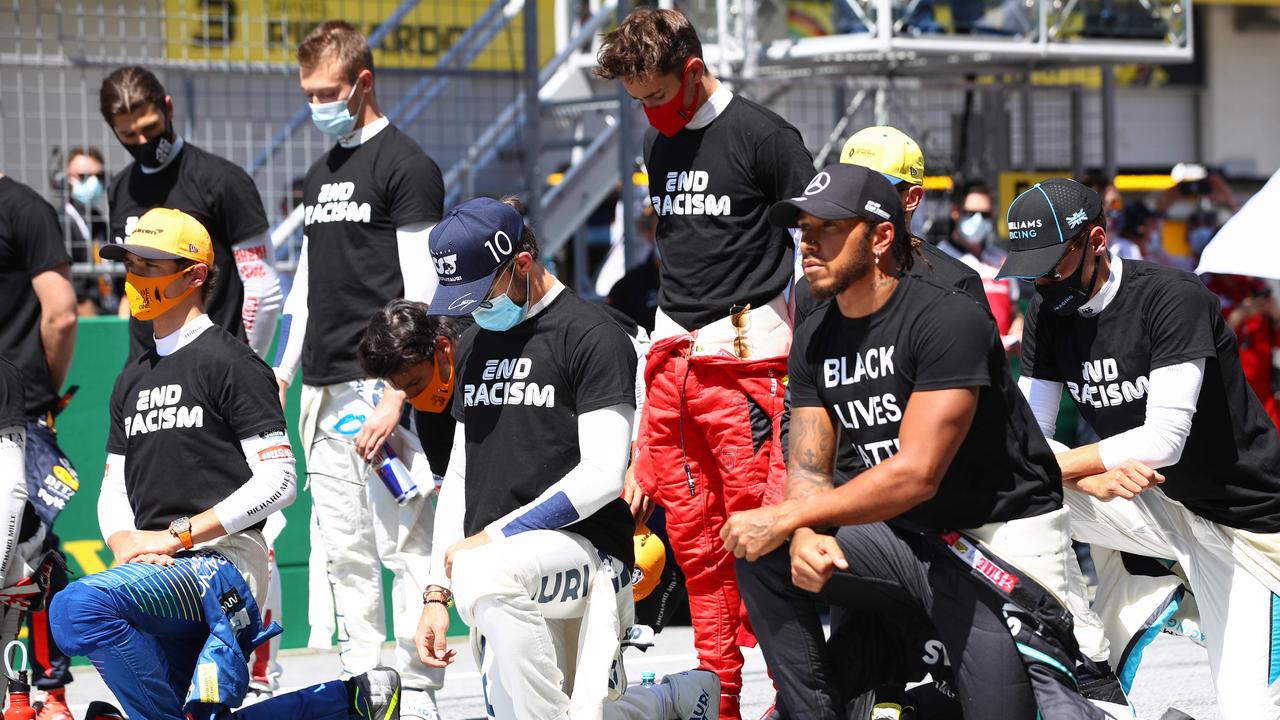 Drivers and team members including Mercedes' British driver Lewis Hamilton (R) take a knee against racism prior to the Austrian Formula One Grand Prix.