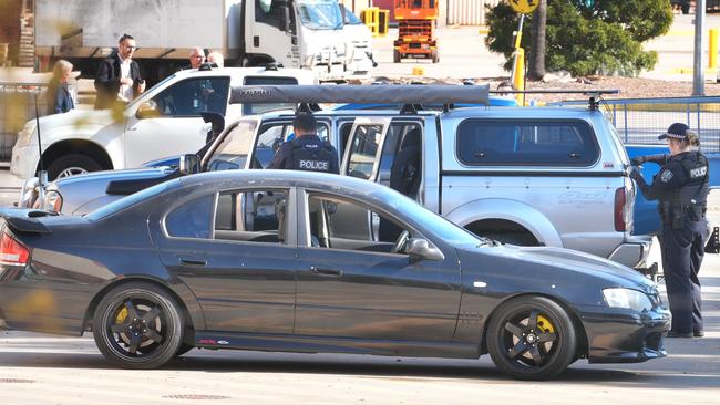 Police officers examine a four-wheel drive in the carpark of the business. Picture: Dean Martin