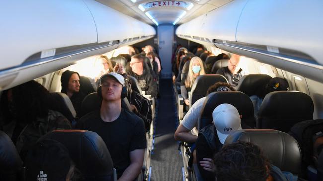 Airline passengers, some not wearing face masks following the end of Covid-19 public transportation rules, sit during an American Airlines flight operated by SkyWest Airlines from Los Angeles International Airport (LAX) in California to Denver, Colorado. (Photo by Patrick T. FALLON / AFP)