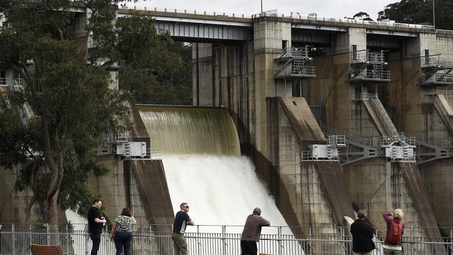 Members of the public watch on as water runs from the Warragamba dam wall. Picture: Ryan Pierse/Getty Images