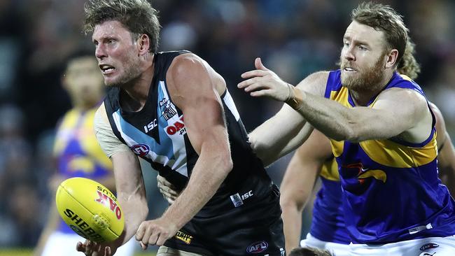 Port Adelaide’s Brad Ebert gets his handpass away from West COast’s Jon Giles. Picture: SARAH REED