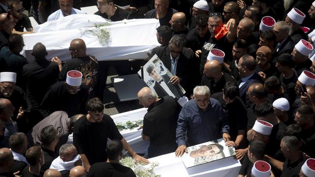 Mourners attend a funeral for ten of the victims of Saturday's rocket attack. Picture: Getty Images.