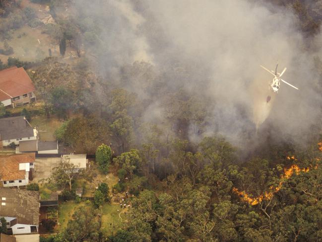 Aerial of water bombing a bushfire from a helicopter, Sydney Australia.