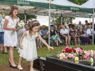 SOLEMN CEREMONY: Rose Robinson and Sophie Griffin lay flowers at the Babies of Walloon grave dedication. Picture: Lyle Radford
