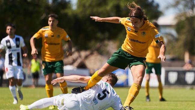 Cumberland United’s Chris Skull tripping over City’s Zakariah Waters at Adelaide City Park on Saturday. Picture: AAP/Matt Loxton