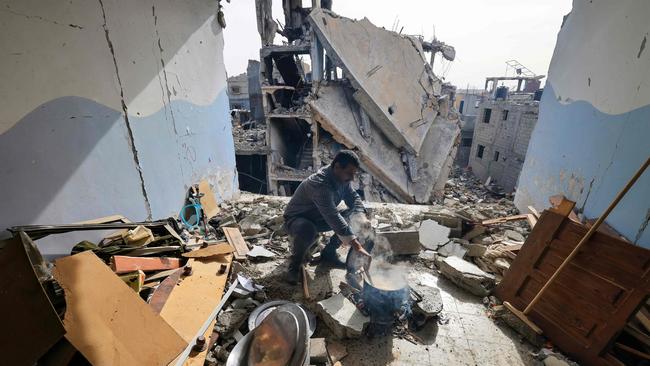 A Gazan cooks inside his damaged apartment in Khan Yunis. Picture: AFP