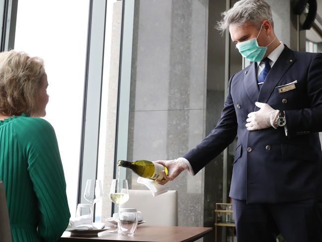 Certified service with a masked smile: hospitality goes on at the Shangri-La Hotel at The Rocks in Sydney. Picture: Richard Dobson