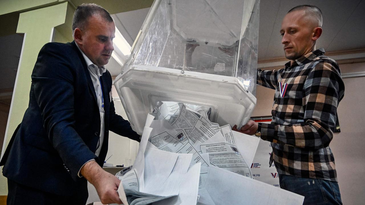 Election officials empty a box of ballot papers. Picture: Alexander Nemenov / AFP