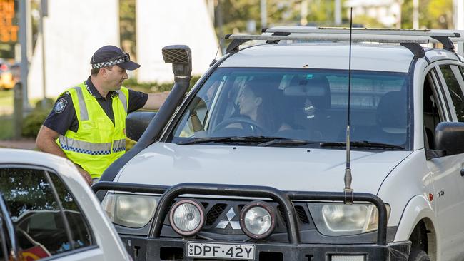 A Queensland Police officer speaks to a motorist at the border. Picture: Jerad Williams