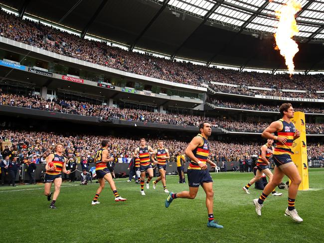 The crows run out, greeted by fire and a roaring MCG. Picture: Getty