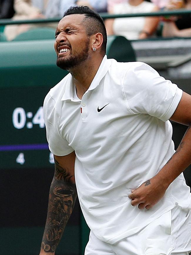 Kyrgios grabs his stomach after serving.